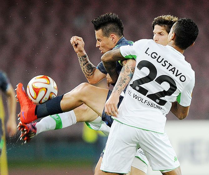 Napoli's Marek Hamsik and VfL Wolfsburg's Luiz Gustavo vie for possession during their UEFA Europa League quarter-final second leg match in Naples on Thursday