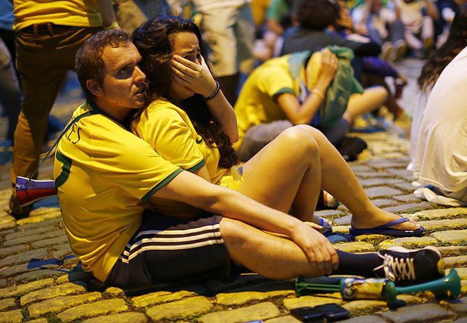 Brazil fans react as they watch their 2014 World Cup semi-finals against Germany on a street in Rio de Janeiro