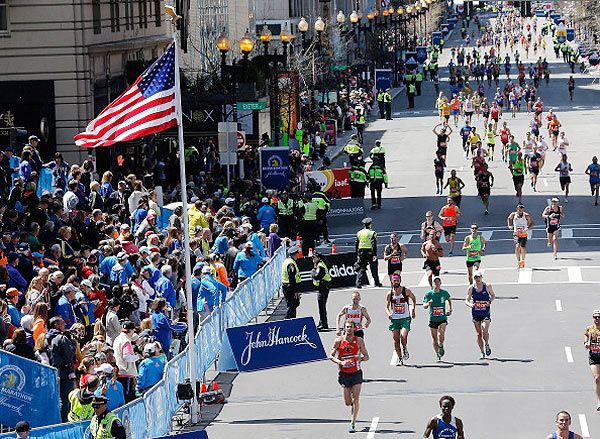 Runners participate at the finish line in the 2014 B.A.A. Boston Marathon on April 21, 2014 in Boston, Massachusetts
