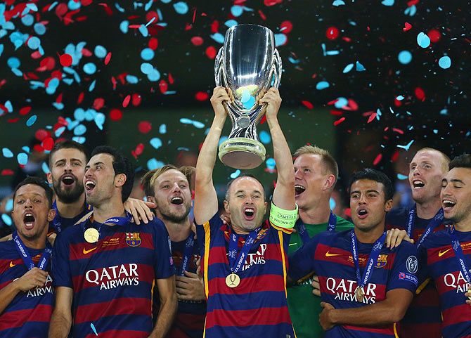 Andres Iniesta lifts the trophy as Barcelona celebrate their UEFA Super Cup victory over Sevilla FC at Dinamo Arena in Tbilisi, Georgia, on Tuesday