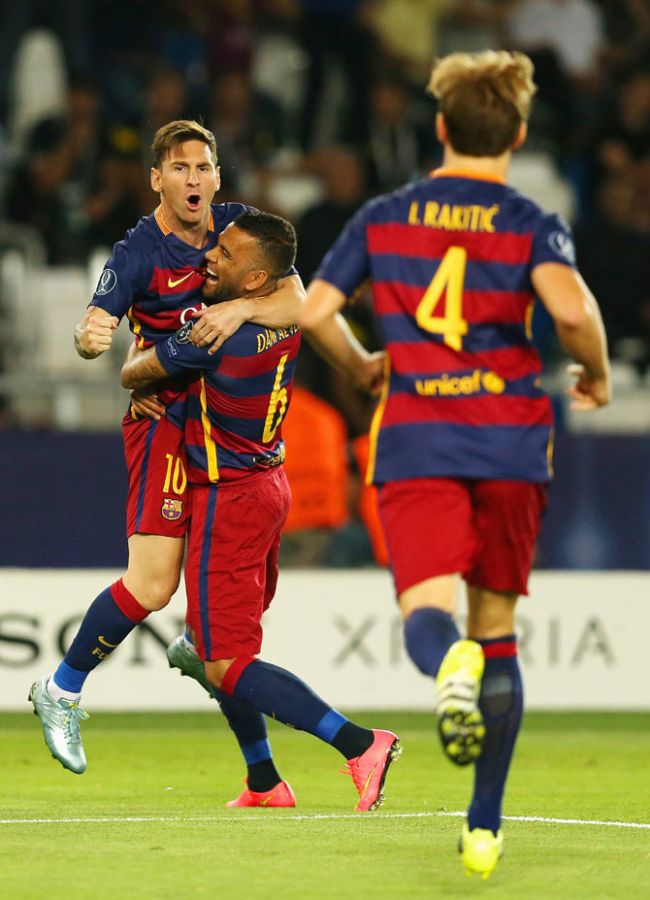 Barcelona'S Lionel Messi is congratulated by teammates Dani Alves and Ivan Rakitic after scoring