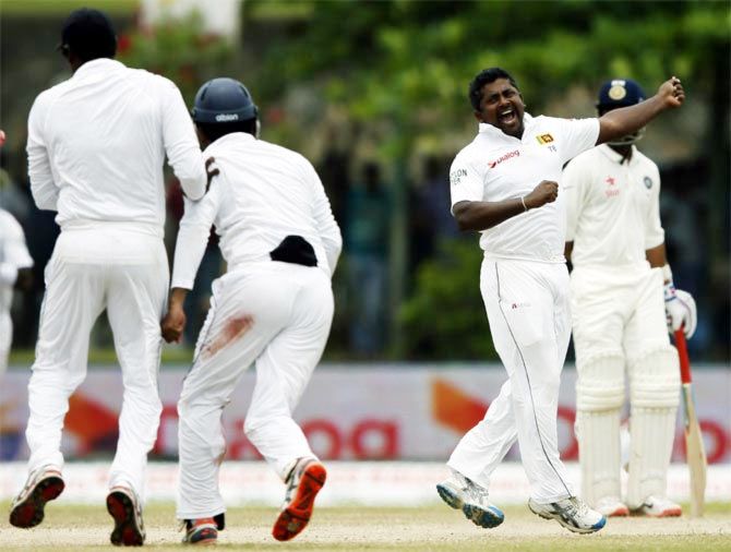 Sri Lanka's Rangana Herath (right) celebrates after taking the wicket of India's Harbhajan Singh