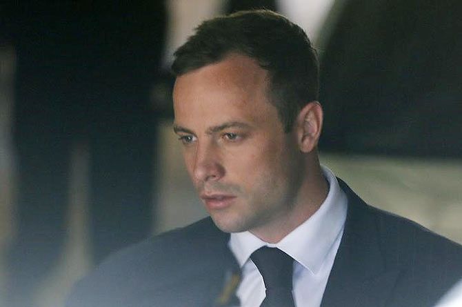 South African Olympic and Paralympic sprinter Oscar Pistorius is led to a prison van after his sentencing in Pretoria on October 21, 2014