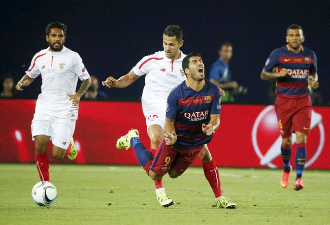 Barcelona's Luis Suarez (centre front) is fouled by Sevilla's Vitolo during their UEFA Super Cup match at Boris Paichadze Dinamo Arena in Tbilisi, Georgia, on Tuesday, August 11, 2015