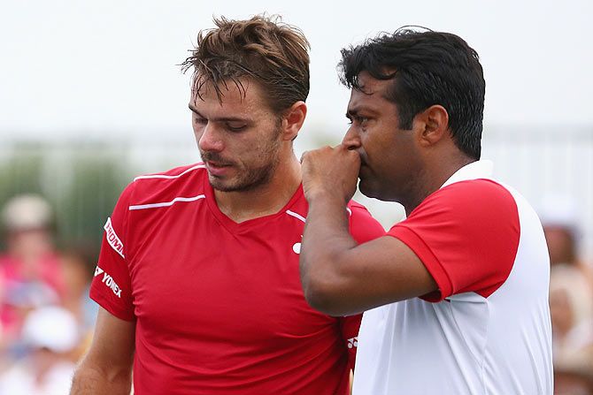 Switzerland's Stanislas Wawrinka and India's Leander Paes discuss tactics during their doubles match at the Western & Southern Open at the Linder Family Tennis Center in Cincinnati, Ohio, on Monday