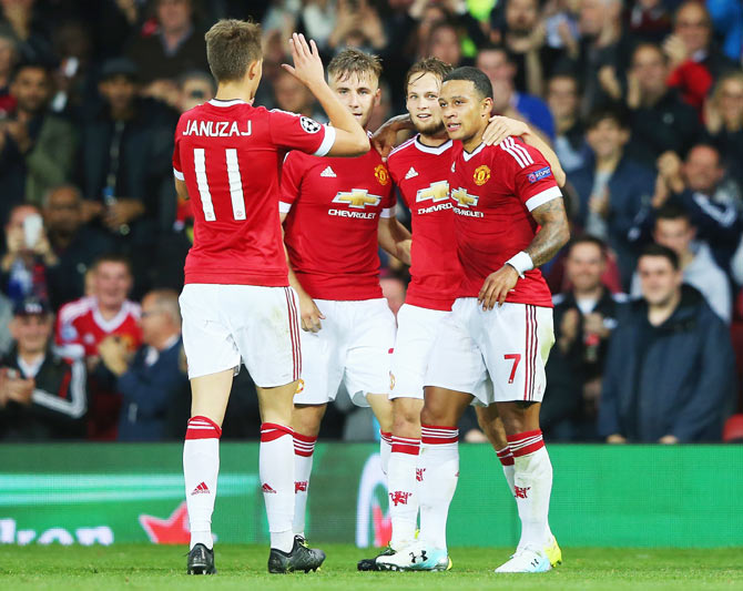 Manchester United's Memphis Depay (right) is congratulated by teammates on scoring his team's second goal during the UEFA Champions League qualifying round play off first leg match against Club Brugge at Old Trafford in Manchester, on Tuesday