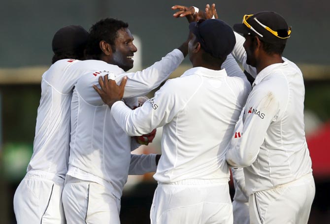 Sri Lanka's captain Angelo Mathews (2nd L) celebrates with his teammates after taking the wicket of India's Rohit Sharma (not pictured) 