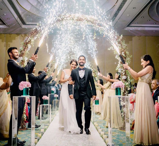 Cricketer Dinesh Karthik and squash ace Dipika Pallikal walk down the aisle after their wedding ceremony in Chennai on Tuesday, August 18