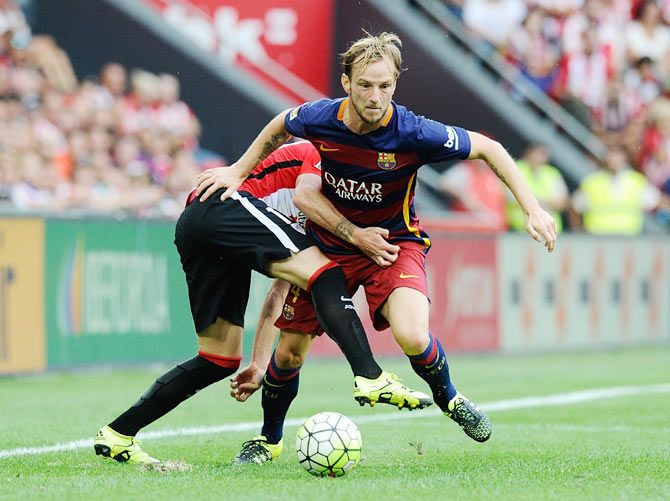 FC Barcelona's Ivan Rakitic is challenged by an Athletic Bilbao player during their La Liga match at San Mames Stadium in Bilbao on Sunday, August 23