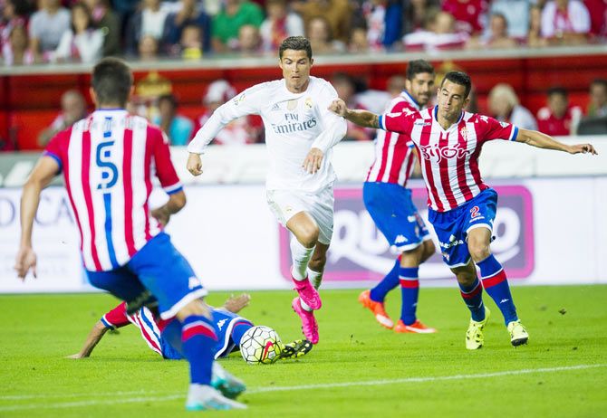 Real Madrid's Cristiano Ronaldo duels for the ball with Sporting Gijon's Luis Hernandez during their La Liga match at Estadio El Molinon in Gijon on Sunday