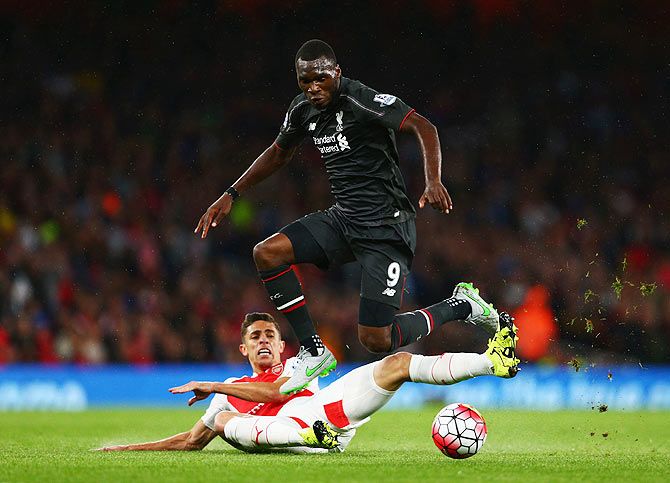 Liverpool's Christian Benteke is challenged by Arsenal's Gabriel Paulista