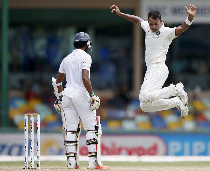 India's Stuart Binny (right) celebrates after taking the wicket of Sri Lanka's Dinesh Chandimal (left)