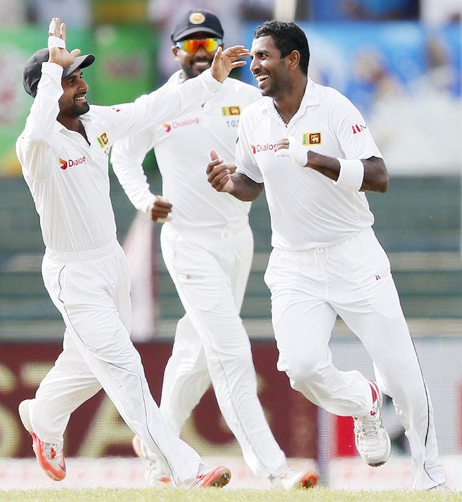 Sri Lanka's Dhammika Prasad (right) celebrates with his teammates Kaushal Silva (left) and Upul Tharanga (centre) after taking the wicket of India's Cheteshwar Pujara on Day 3 of the third and final Test match in Colombo on Sunday