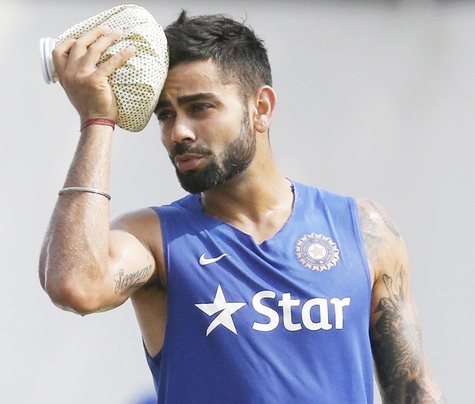 India's captain Virat Kohli uses an ice pack on his head during a practice session 