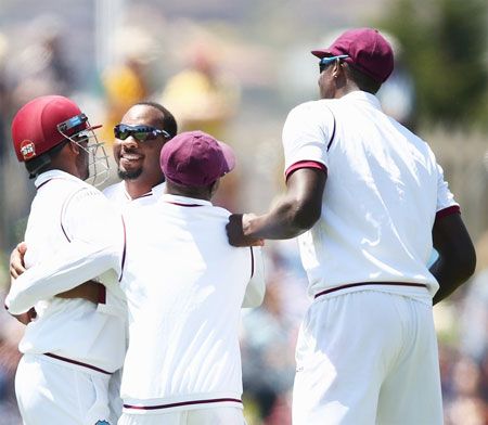West Indies's Jomel Warrican celebrates dismissing Australia's David Warner during Day 1 of the first Test at Hobart