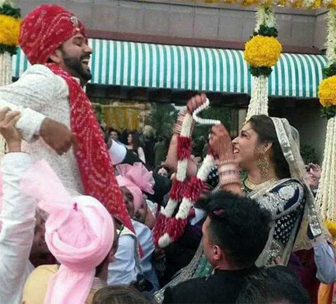 Rohit Sharma's friends lift him as bride Ritika tries to put the garland around his neck 