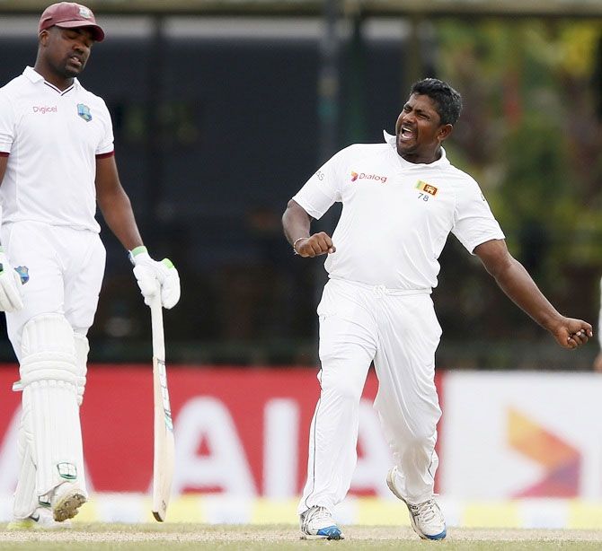 Sri Lanka's Rangana Herath, right, celebrates after taking the wicket of West Indies' Denesh Ramdin (not pictured) during the final day of their second Test match against the West Indies