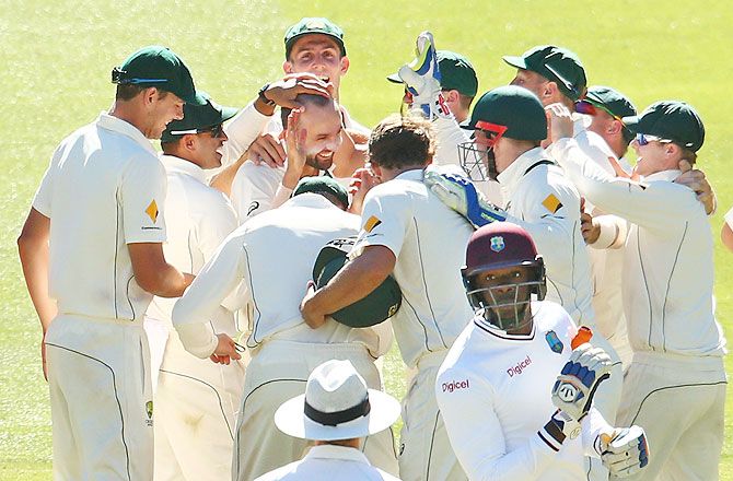 Australia's Nathan Lyon is congratulated by his teammates after taking the wicket of West Indies' Carlos Brathwaite