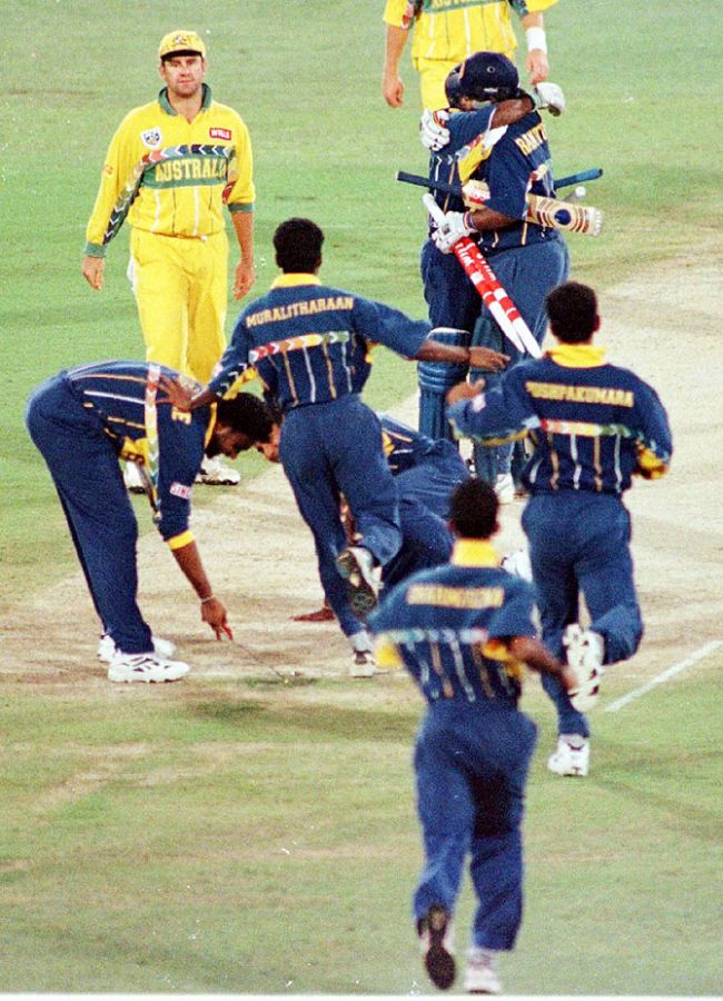 Sri Lankan team members rush onto the wicket to celebrate with batsmen Arjuna Ranatunga and Aravinda De Silva (hugging) after they beat Australia to win the World Cup at the Gaddafi stadium in Lahore on March 17, 1996