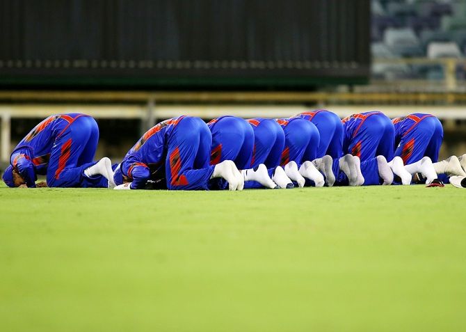Players from Afghanistan pray