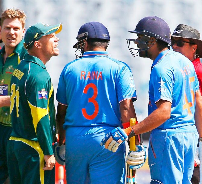 Umpires and Australia's James Faulkner (2nd left) watch as Australia's David Warner argues with India's Rohit Sharma during their ODI tri-series match at the Melbourne Cricket Ground