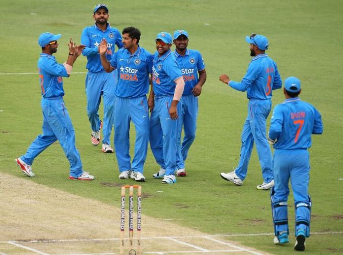 Indian players celebrate after a fall of a wicket