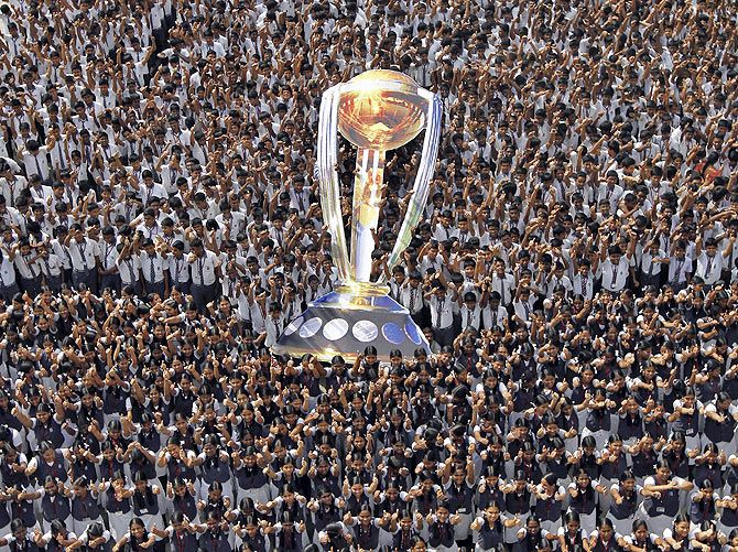 Students wish the Indian cricket team luck, as they hold a giant cut-out replica of the Cricket World Cup trophy, at a school in Chennai on Thursday