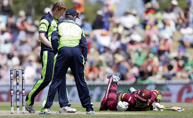West Indies batsman Darren Sammy makes his ground as he is watched by Ireland's William Porterfield (2nd from left) and George Dockrell (left)