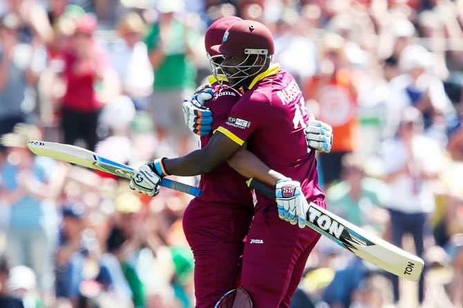 Lendl Simmons of the West Indies is congratulated by teammate Andre Russell on completing his century
