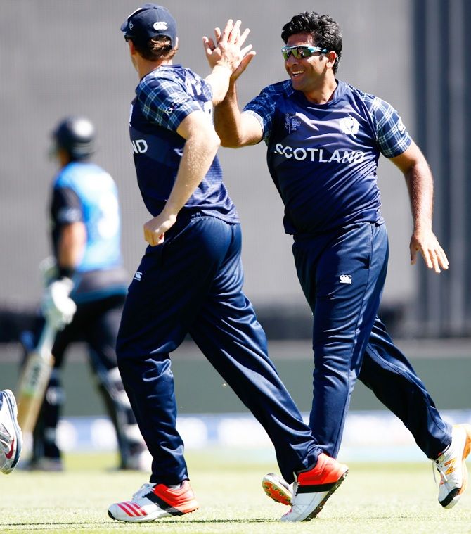 Majid Haq of Scotland, right, celebrates the wicket of Ross Taylor of New Zealand