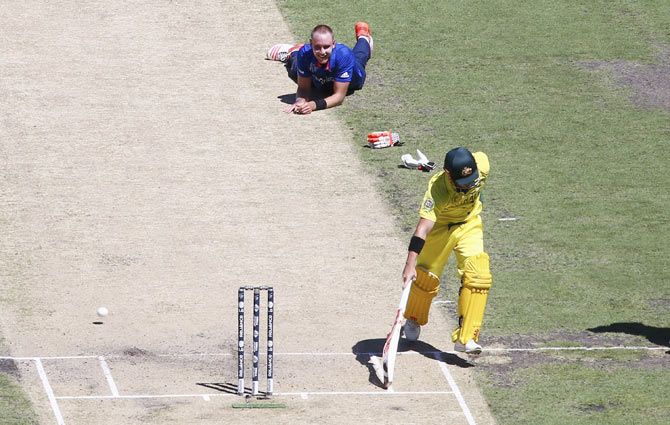 Stuart Broad of England looks on after falling over while bowling as David Warner of Australia runs back to his crease 