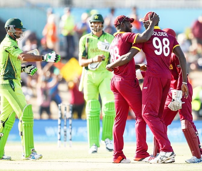 West Indies team mates celebrate a wicket