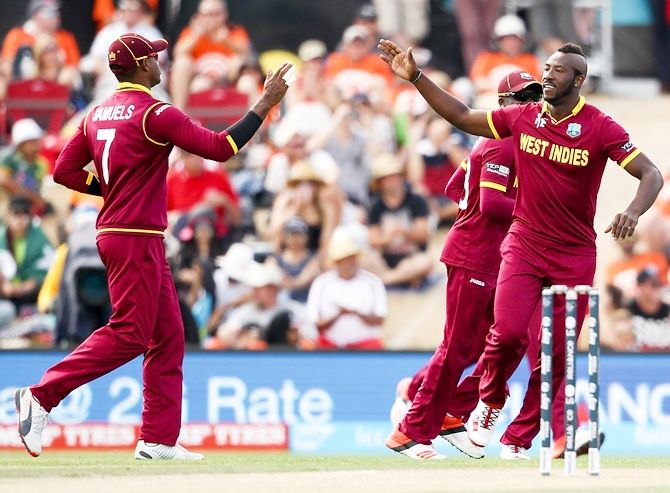Andre Russell, right, of the West Indies celebrates
