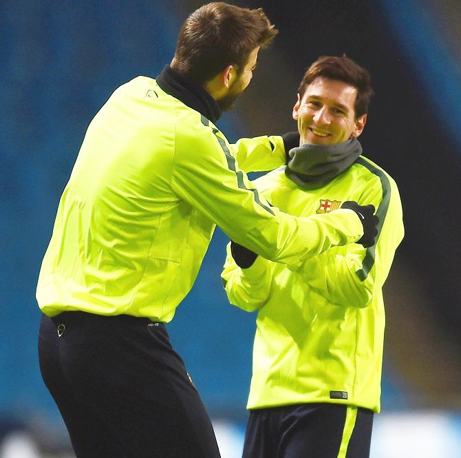 Gerard Pique, left, shares a joke with Lionel Messi of Barcelona during a Barcelona training   session