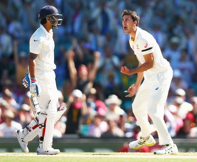 Mitchell Starc of Australia celebrates taking the wicket of Murali Vijay