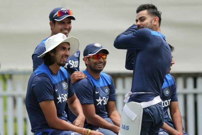 Virat Kohli (right) speaks to his teammates during a training session