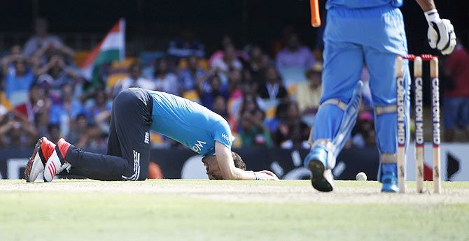England's bowler James Anderson (left) reacts after missing a catch off India's Stuart Binny