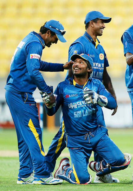 Kumar Sangakkara of Sri Lanka is congratulated by teammate Dimuth Karunaratne after taking a catch to dismiss Corey Anderson of New Zealand and break the world record for most catches by a wicketkeeper during their One-Day International at Westpac Stadium in Wellington on Wednesday