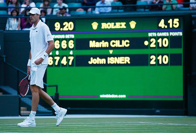 American John Isner leaves the court after play was suspended due to bad light in the third round match against Croatia's Marin Cilic on Friday