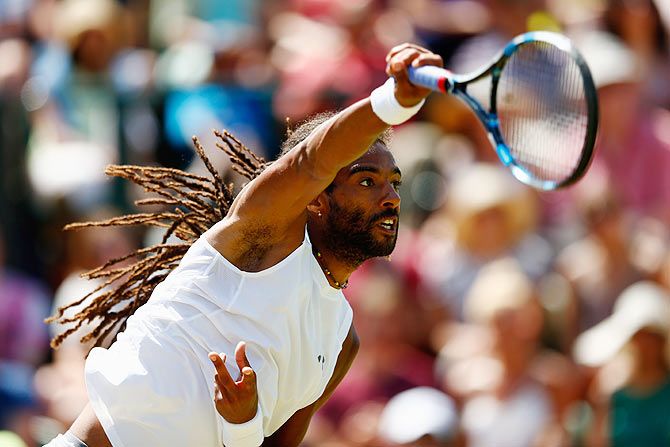 Germany's Dustin Brown serves in his third round match against Serbia's Victor Troicki on Saturday