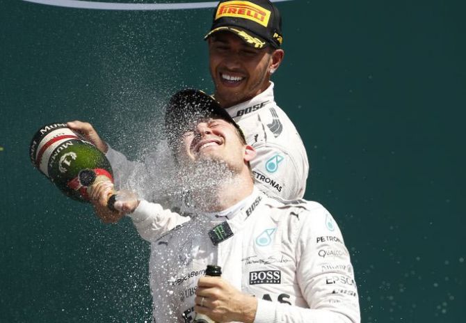 Mercedes' Lewis Hamilton celebrates on the podium with teammate Nico Rosberg after winning the British Grand Prix at Silverstone on July 5