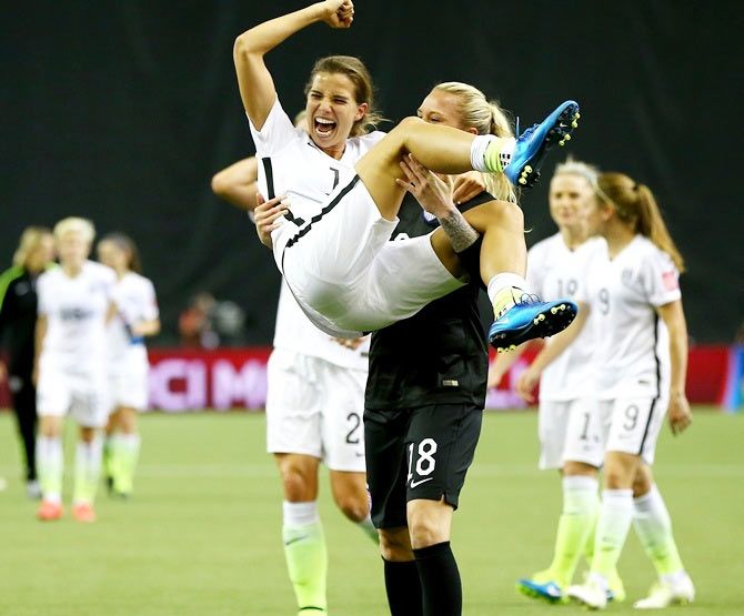 United States midfielder Tobin Heath (17) celebrates with teammate Ashlyn Harris (18) after defeating Germany in the FIFA 2015 Women's World Cup semi-finals at Olympic Stadium. United States won 2-0. 