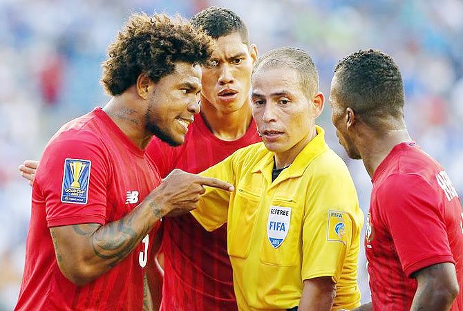 Panama defender Roman Torres (left) argues with referee Marlon Mejia after a penalty was awarded to Honduras