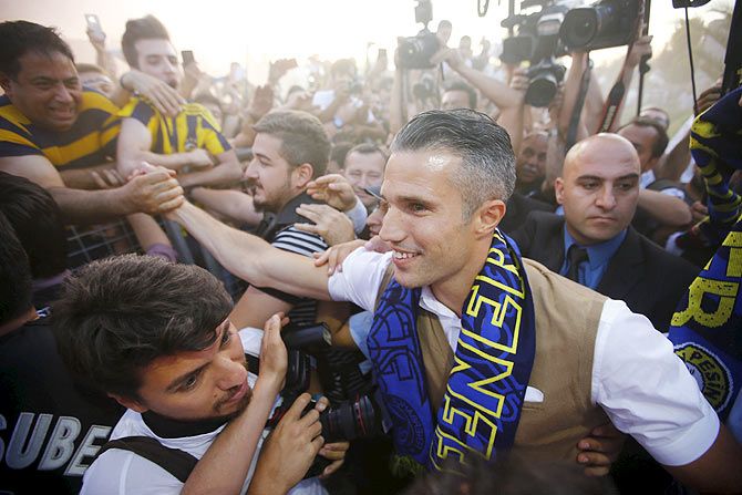 Netherlands striker Robin van Persie greets Fenerbahce supporters upon his arrival at Sabiha Gokcan Airport in Istanbul on Sunday