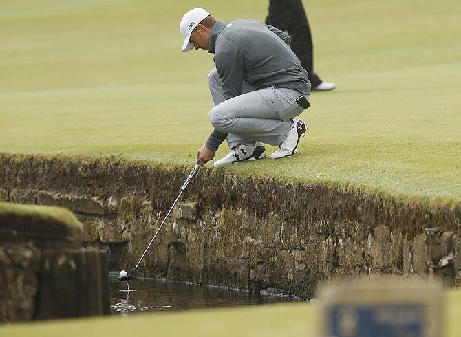 American golfer Jordan Spieth retrieves his ball from the Swilcan Burn on the first hole during a practice round ahead of the British Open golf championship on the Old Course in St. Andrews, Scotland, on Wedneday, July 15
