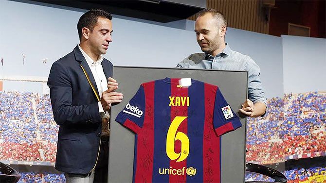 Andres Iniesta presents Xavi a huge cut-out of his jersey