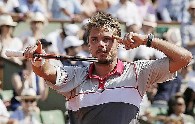 Switzerland's Stan Wawrinka celebrates after defeating France's Jo-Wilfried Tsonga in their men's semi-final at the French Open at the Roland Garros stadium in Paris on Friday