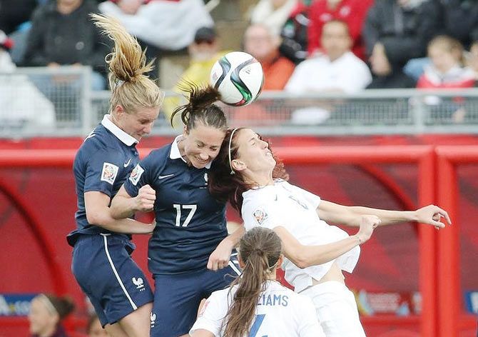 England midfielder Jill Scott (8) goes up for a header against France's Amandine Henry (left) and Gaetane Thiney (17) during their Group F match at Moncton Stadium in New Brunswick, on Tuesday