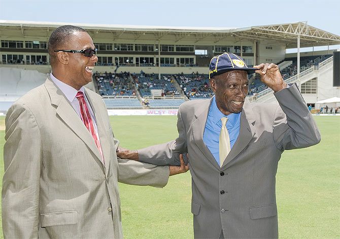 Wes Hall receives his commemorative cap from countryman and Hall of Famer Courtney Walsh