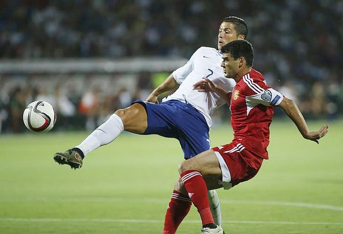 Portugal's Cristiano Ronaldo scores the second goal past Armenia's Robert Arzumanyan (right)